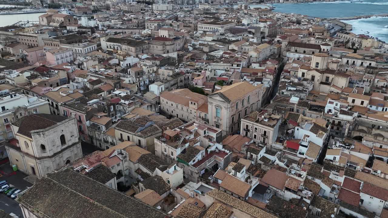 Toma aérea con dron sobre los densos tejados de la Isla de Ortigia en Siracusa, Sicilia. Vista cenital de arquitectura mediterránea histórica, calles estrechas y edificios italianos de piedra caliza