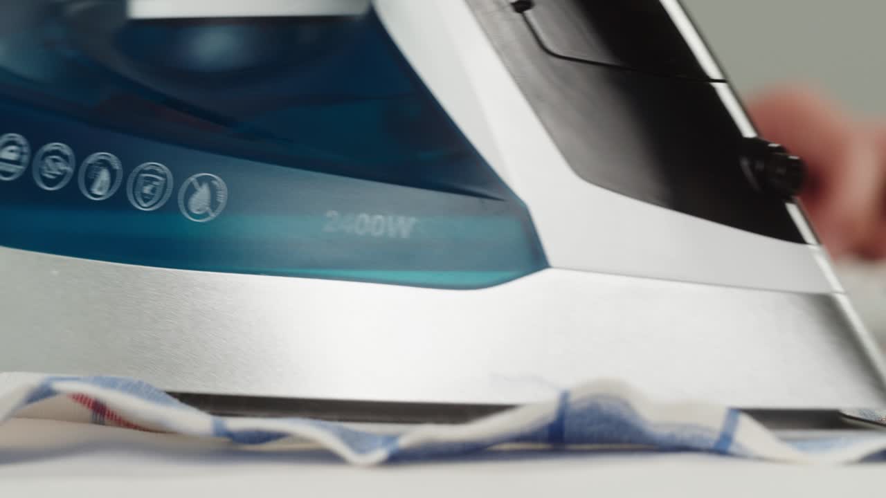 Close-up of a Steam Iron Pressing a Checkered Cloth