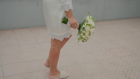 bride walking with flower bouquet indoors