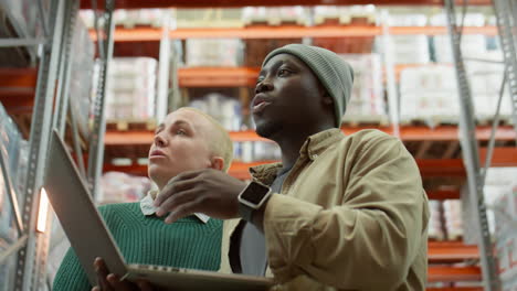 warehouse workers collaborating with laptop