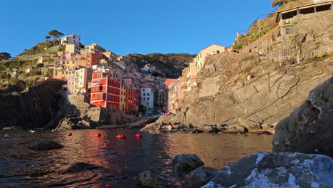 vibrant coastal view of riomaggiore, showcasing colorful buildings and serene water