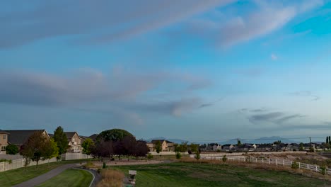 sunset to darkness with the moon rising over a suburban neighborhood - panoramic motion time lapse