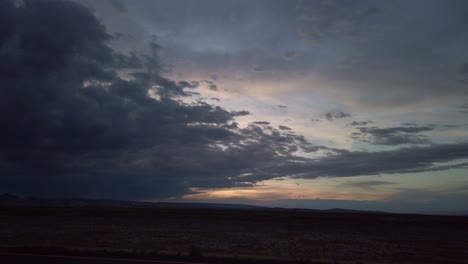 wide static shot of storm clouds during a desert sunset