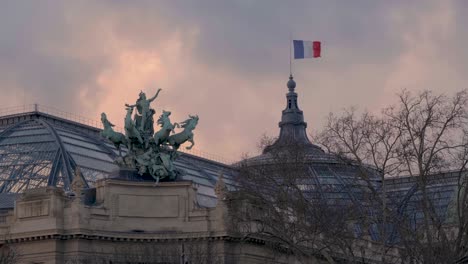French flag floating over the statue of the Grand Palais in Paris