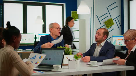 jefe de equipo de empresarios de alto rango discutiendo con un colega usando papeleo