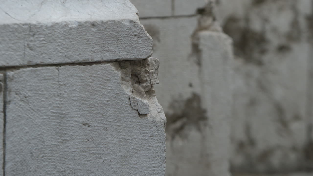 Close up rack focus of damaged Cathedral exterior details from mortar shelling in the Siege of Sarajevo war, in Bosnia and Herzegovina