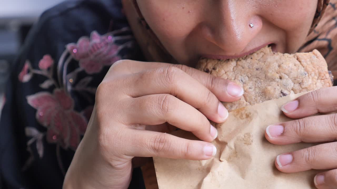una mujer comiendo una galleta de chocolate