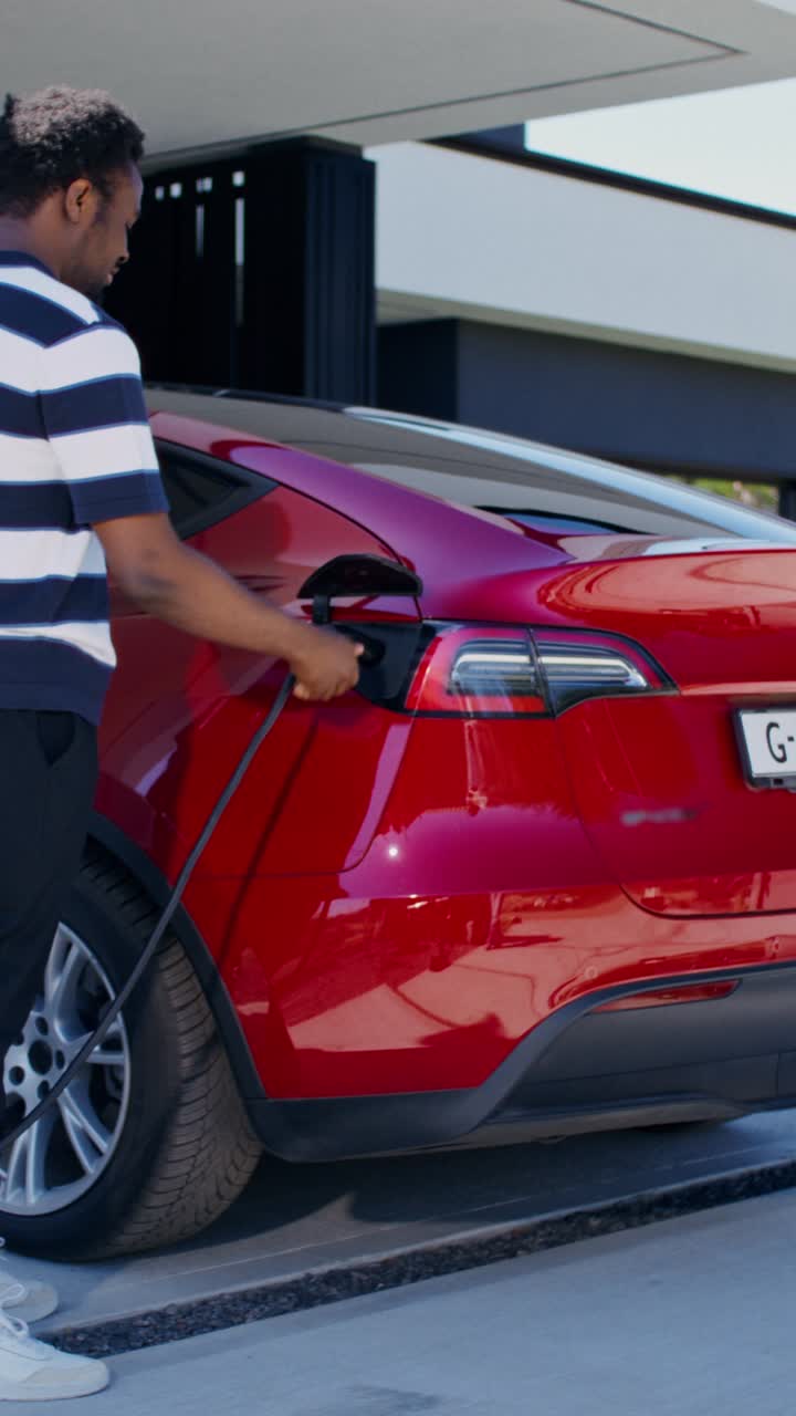 hombre cargando coche eléctrico en casa