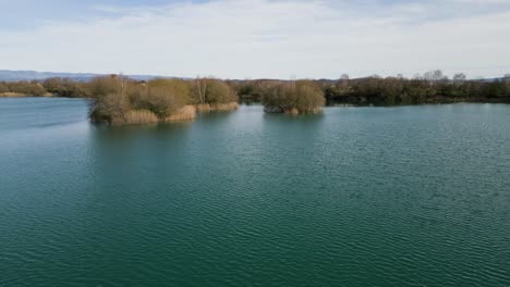 Wind-Kräuselt-Sich-über-Grünes-Wasser-Mit-Schilfinseln-In-Der-Antiken-Lagune-Von-Antela,-Areeiras-Da-Limia-In-Xinzo-De-Limia,-Ourense,-Galizien,-Spanien