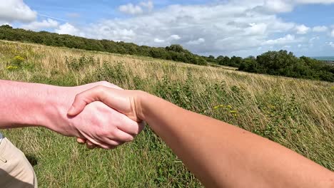 two people shaking hands in a field