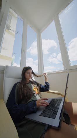 woman working from home on laptop by window