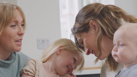 same sex female couple having healthy breakfast at home with daughter and baby son