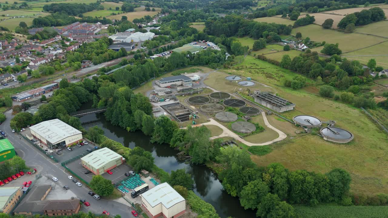 Scenic aerial drone view of rural wastewater plant with settling tanks and ponds in Derbyshire Dales UK