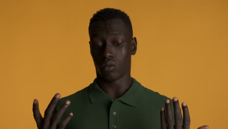 un hombre afroamericano asustado sobre un fondo amarillo.