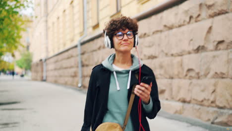 young woman walking and listening to music in the city