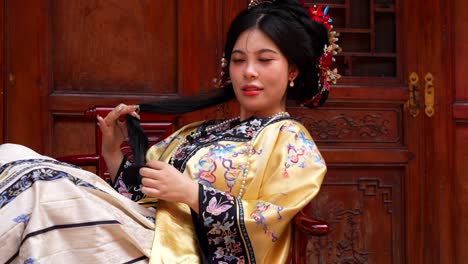 hermosa mujer china en la dinastía qing tradicional vestida jugando con su cola de caballo