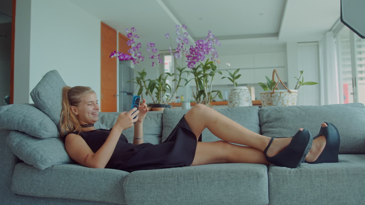 Teenage Girl Relaxing on Sofa with Smartphone