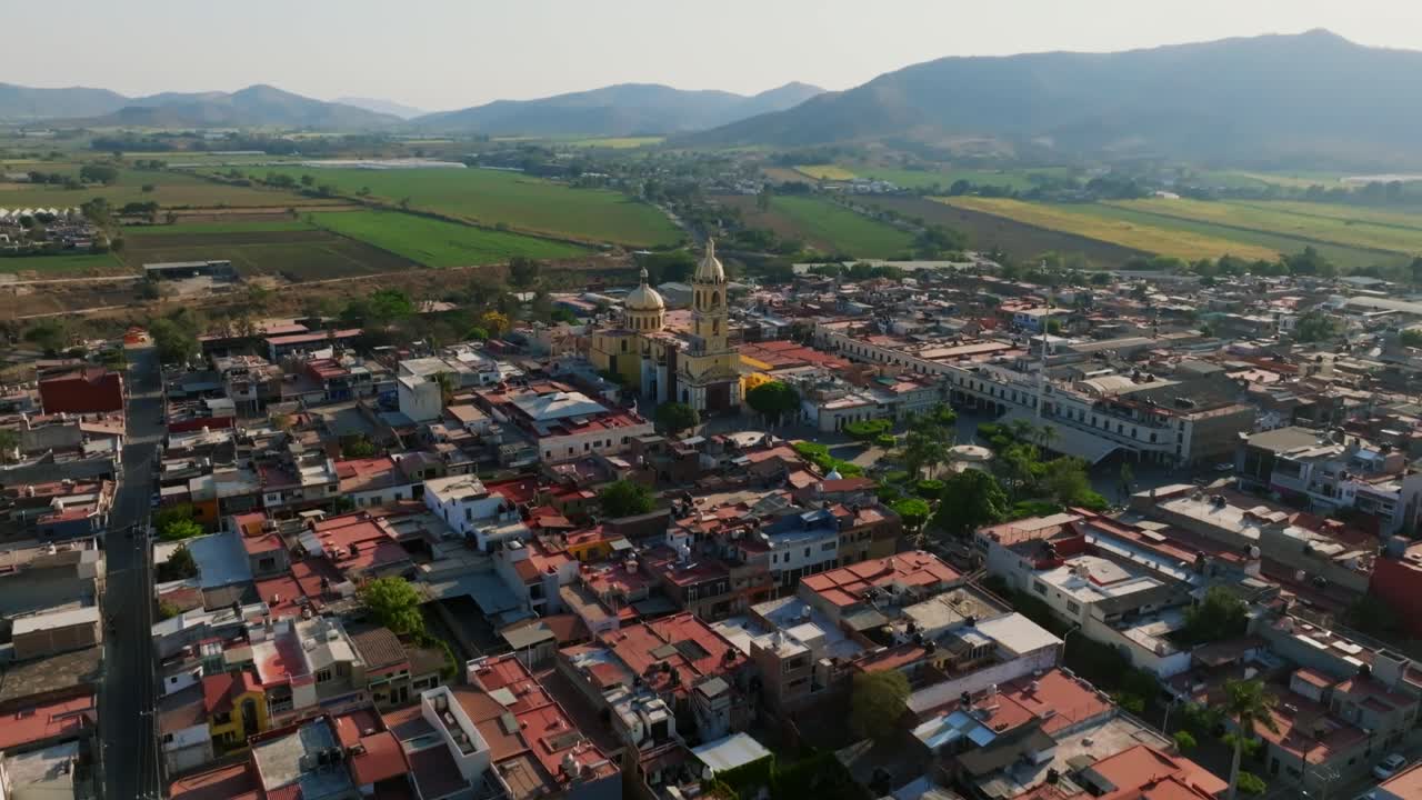 dolly en vuelo inclinado sobre un área residencial revela la iglesia santuario diosesano en el centro de la ciudad de tamazula