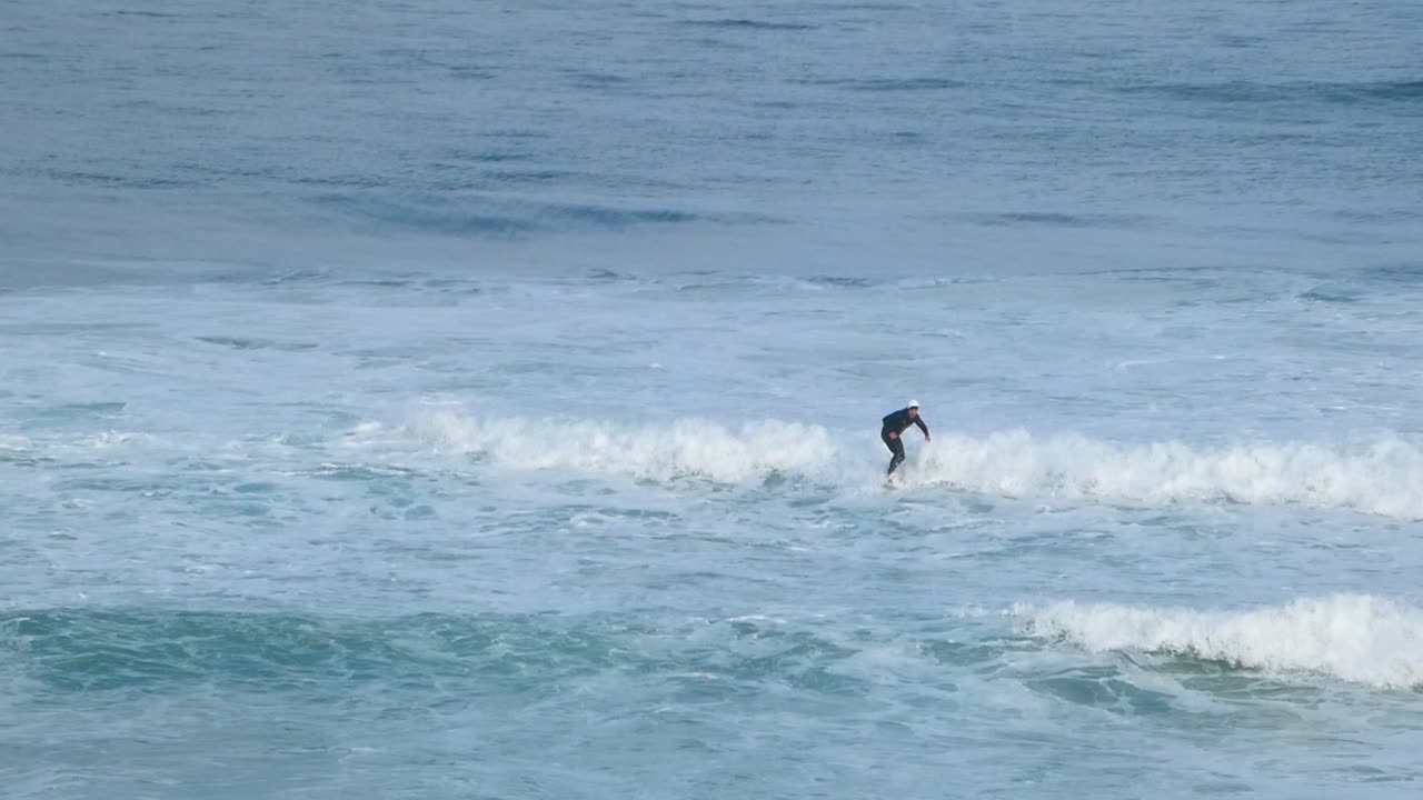 Young man surfs the ocean wave in the Guincho and aggressively turns on the lip
