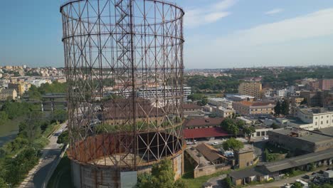 Luftdrohne-Vorwärts-Bewegende-Aufnahme-Einer-Alten-Eisenkonstruktion,-Gazometro-Im-Bezirk-Ostiense,-Rom,-Italien-Während-Der-Abendzeit