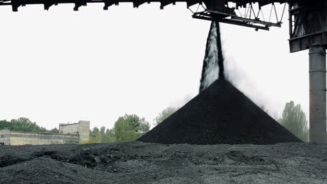 heap of coal outdoors. machine supplies coal for industrial work in power plant