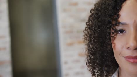 medio retrato de una feliz mujer de negocios biracial mirando a la cámara y sonriendo, espacio de copia, cámara lenta