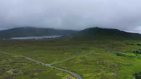 western way, leenane, connemara, county galway, july 2021. drone slowly tracks north while facing south, following the course of a country road as low-hanging clouds drift across the mountains