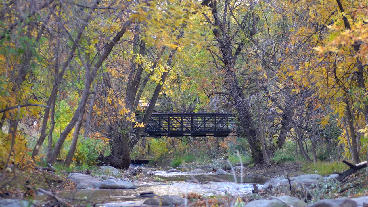 hombre corriendo en un puente peatonal a lo largo del arroyo boulder