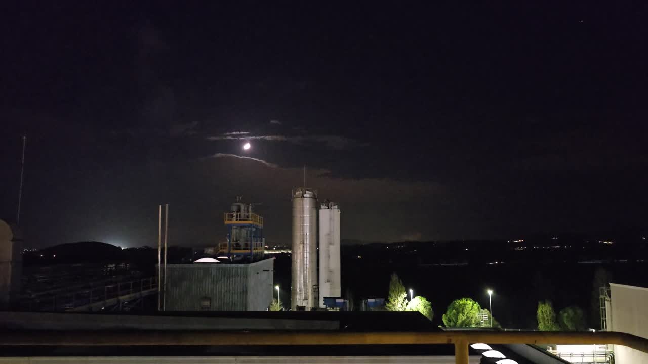 General shot at night in a chemical factory. In the horizont Mon in the black night. Two chinney not work