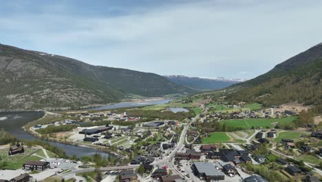 lom and fossbergom with bovra river mouth in norway - high angle backward moving aerial