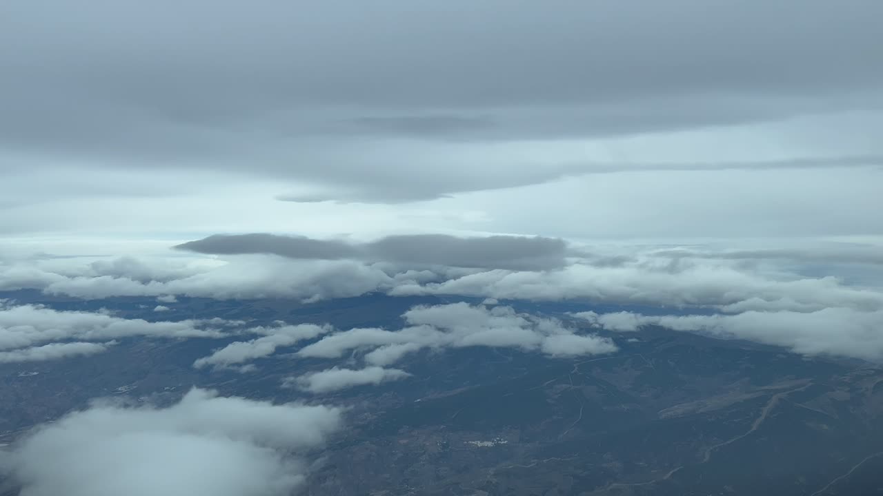 volando a través de un dramático cielo de invierno un montón de nubes de nieve, como se ve por los pilotos en un vuelo real