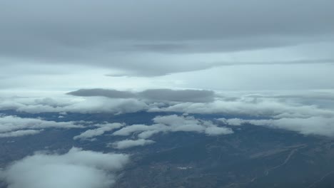 Flying-through-a-dramatic-winter-sky-plenty-of-snow-clouds,-as-seen-by-the-pilots-in-a-real-flight