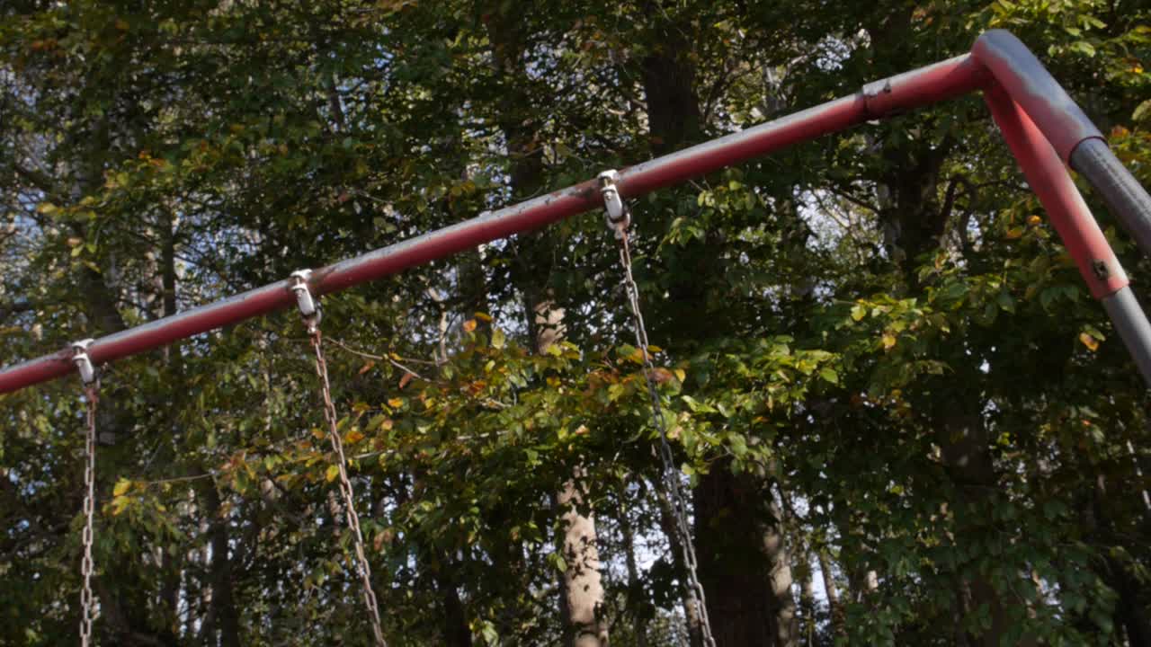 Close up and pan shot of a creaky, empty swing.  Spooky!
