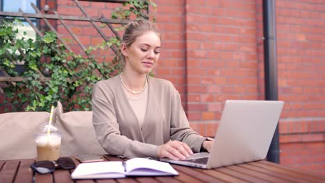 mujer trabajando en una computadora portátil en un café