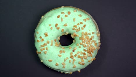 tasty and fresh sprinkled donut close-up macro shot spinning on a black background.