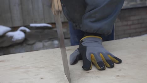 Un-Hombre-Con-Guantes-Cerca-De-Terminar-De-Cortar-Las-Tablas-De-Madera---Plano-Medio