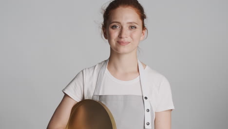 redheaded waitress in front of camera on gray background.