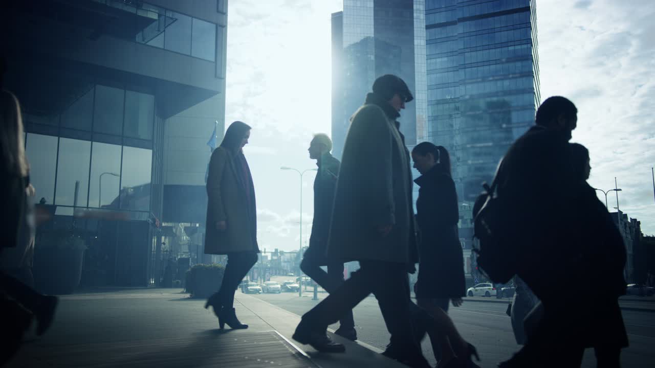 다양하고 다문화적 인 사무실 관리자 및 사업가들은 아침에 출근하거나 구름이 많은 날 사무실에서 걸어서 출퇴근합니다. 보행자는 스마트 캐주얼 옷을 입고 스마트 폰을 사용하는 사람들입니다.