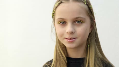 Girl with braided blonde hair and yellow eyeliner