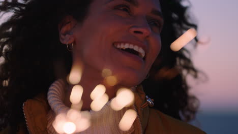 close up sparklers portrait of happy woman celebrating new years eve enjoying independence day celebration having fun on beach at sunset