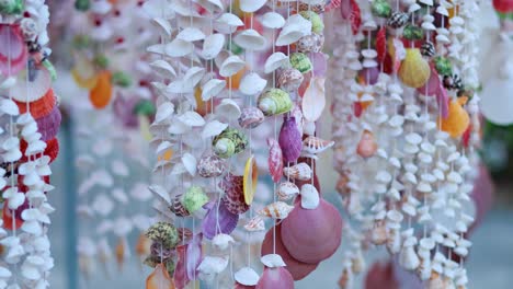 vibrant shell decorations gently sway in the breeze, showcasing intricate designs and colors in an outdoor setting in phuket, thailand
