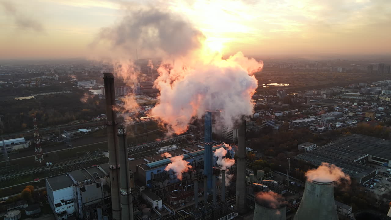 Power station with a lot of tubes and facilities in Bucharest at sunset, a lot of foam from inside a tube. cityscape, view from the drone, Romania