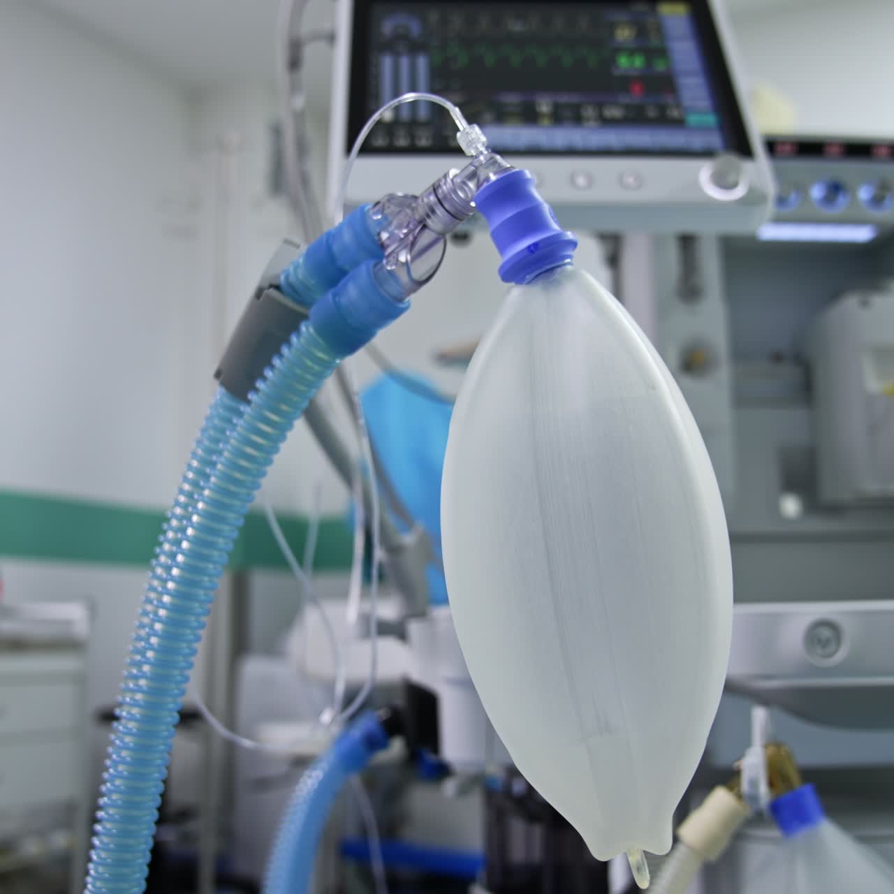 Ambu bag slowly filling with air. Modern machine for lung ventilation at backdrop in blur