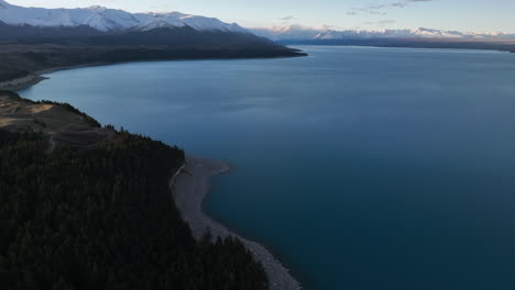 Vista-Del-Atardecer-Sobre-El-Lago-Pukaki-Con-Montañas-Cubiertas-De-Nieve-En-La-Distancia,-Isla-Sur-De-Nueva-Zelanda