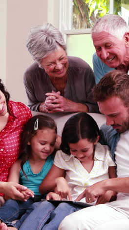 familia sonriente usando una tableta en el sofá