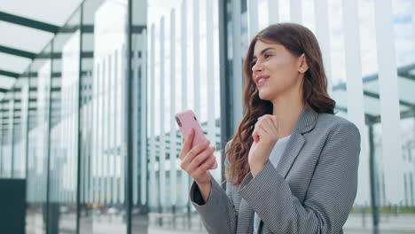 young woman reacting to good news on her smartphone