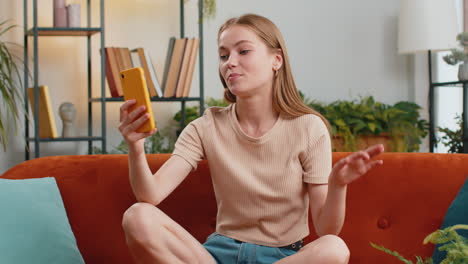 young blonde woman taking selfie on smartphone communicating video call home online with subscribers