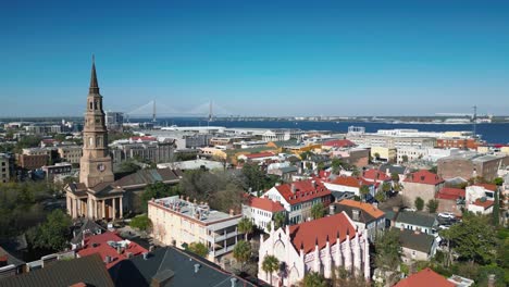 a moving drone shot of the skyline in downtown charleston south carolina with the ravenel bridge visible