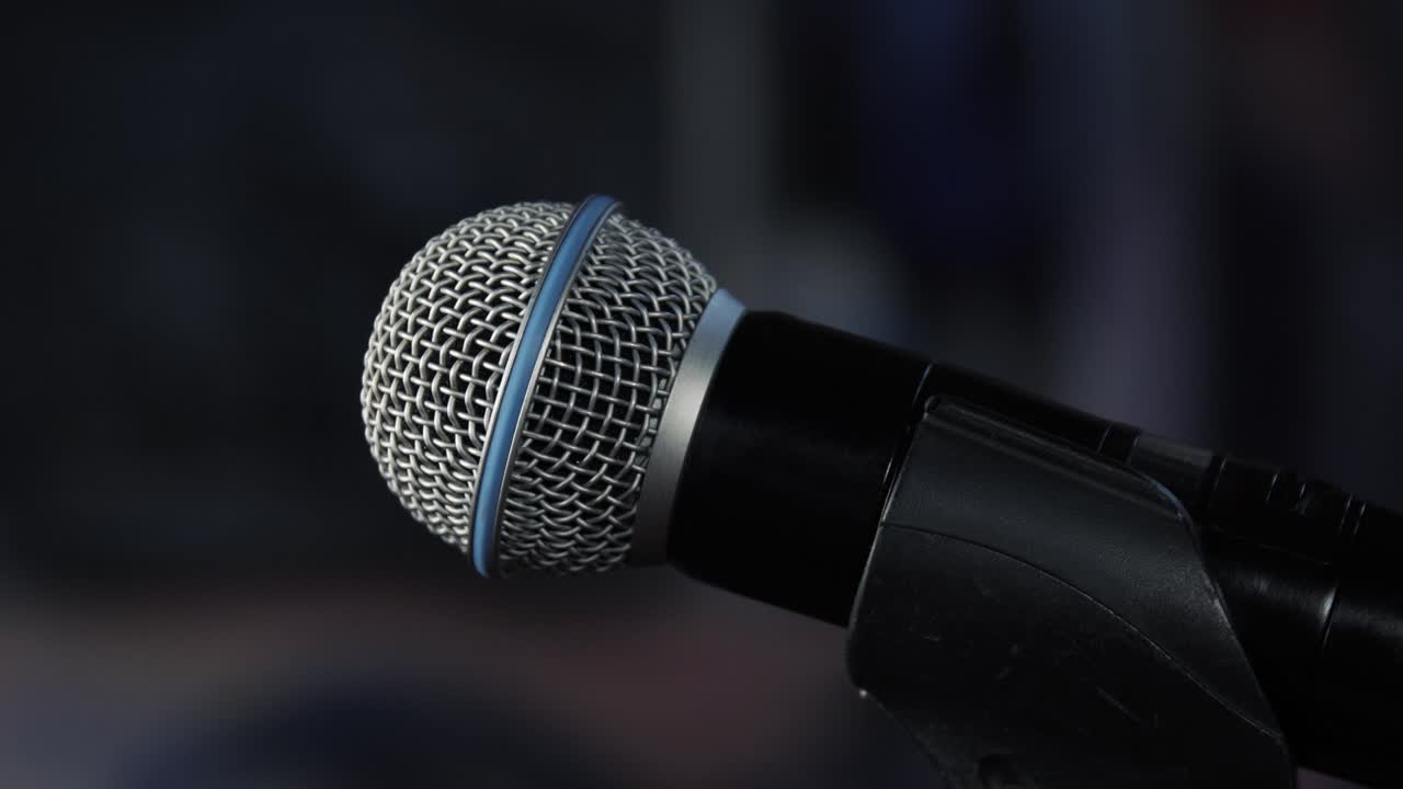 Dynamic microphone on a stand, ready for performance or recording in a dim setting