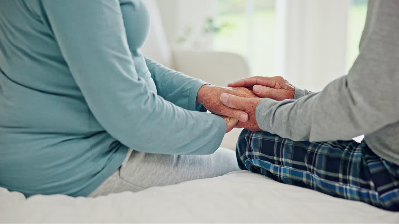 pareja de ancianos tomados de la mano en casa para recibir apoyo